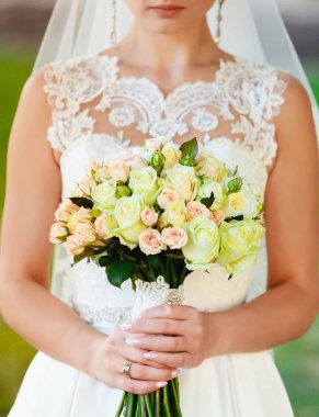 gelin buketi onun önünde tutuyor