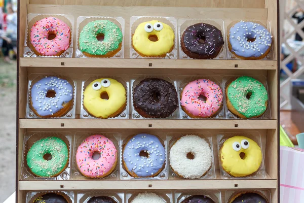 Ahşap vitrin üzerinde çeşitli lezzetli renkli donut görünümü kapatın