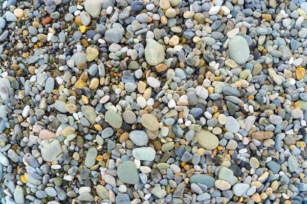 Гладкие круглые булыжники на фоне морской текстуры. Камушек на пляже . — стоковое фото