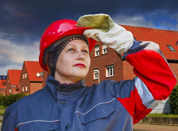 The woman in protective working clothes. labor protection .Under construction . Under construction .  Construction site . Work safety . A helmet for protection of the head . Working gloves . Industrial protective wear . Ukraine. Kiev. Sadovaya Stre