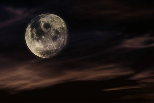 Night sky with the moon . Full moon . Nighttime sky with clouds and bright full moon.