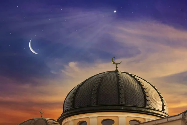 Crescent moon with beautiful sunset background .  Light from sky . Religion background . Red sunset and moon . Against the background of clouds . beautiful sky . Yellow and pink clouds . Sunset and new moon . Prayer time . Generous Ramadan