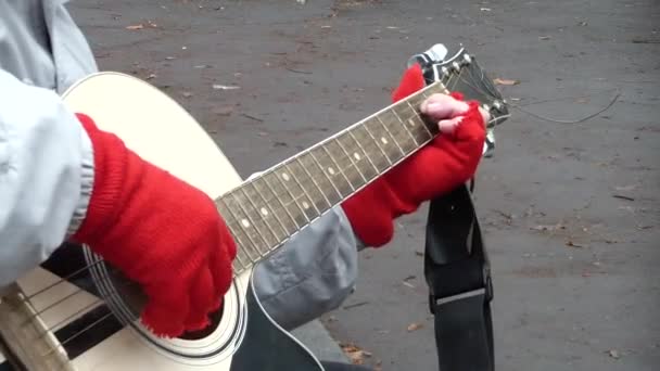 音乐家在城市街道上弹奏吉他 演奏吉他的音乐家双手合拢 — 图库视频影像