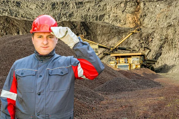 Hard work . red protective helmet . the worker in special clothes . A helmet for protection of the head. Mining and quarries .  Dangerous production. Labor protection