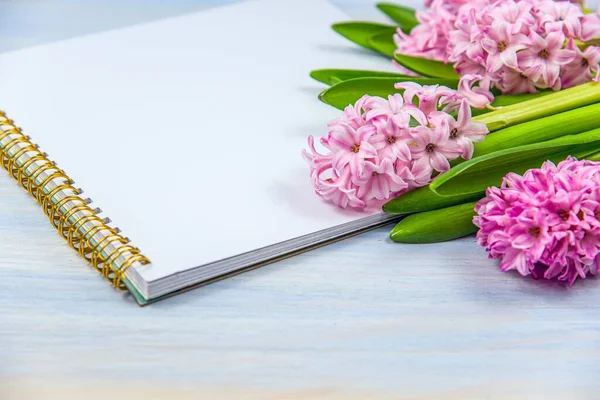 Notebook and flowers on the table. spring mood . Blank greeting card or wedding invitation with lilac flowers