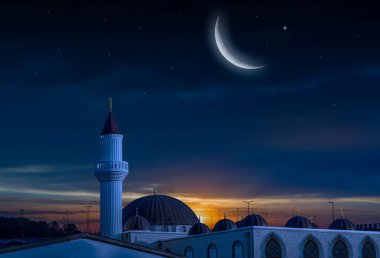Gece gökyüzü ve ay. Günbatımına karşı cami