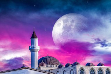 Gecenin pembe bulutlarında bir ay. Gökyüzünün arka planına karşı cami