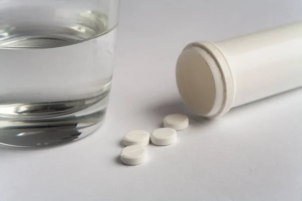 Beyaz hap ve hap şişe ile su beyaz arka plan ilaç eczane sağlık