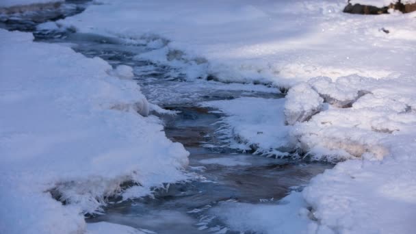 Snow and ice on the banks of a mountain river with crystal clear water in the Caucasus Mountai — Stock Video