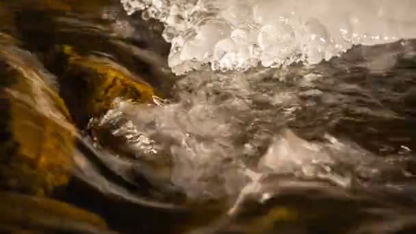 Nieve y hielo a orillas de un río de montaña con aguas cristalinas en las montañas del Cáucaso . — Vídeo de stock