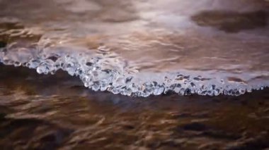 Kar ve buz Kafkasya dağlarında kristal berraklığında su ile bir dağ nehir kıyısında.