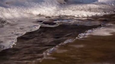 Kar ve buz Kafkasya dağlarında kristal berraklığında su ile bir dağ nehir kıyısında.