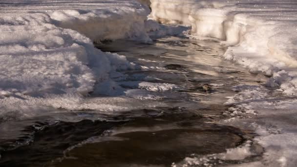 Снег и лед на берегах горной реки с кристально чистой водой в горах Кавказа . — стоковое видео