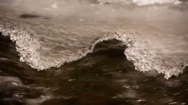 Kar ve buz Kafkasya dağlarında kristal berraklığında su ile bir dağ nehir kıyısında.