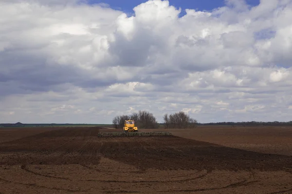 Landbouw. De trekker bereidt het veld voor de inzaai van tarwe in het vroege voorjaar in de steppen van Kalmukkië tijdens een onweersbui. — Stockfoto