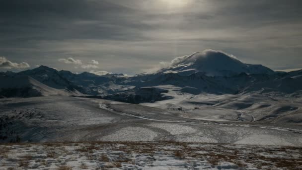 The formation and movement of clouds above the volcano Elbrus in the Caucasus Mountains in winter. — Stock Video