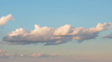 Oluşumu ve hızlı hareket beyaz bulutlar geç bahar gün batımında mavi gökyüzünde farklı şekiller.