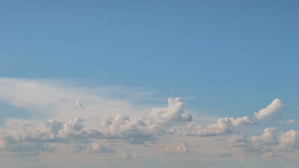 Vorming en snelle beweging van de witte wolken van verschillende vormen in de blauwe lucht in het late voorjaar bij zonsondergang. — Stockvideo