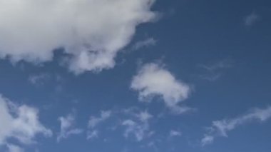 Rusya, zaman atlamalı. Oluşumu ve hızlı hareket beyaz bulutlar geç bahar gün batımında mavi gökyüzünde farklı şekiller.