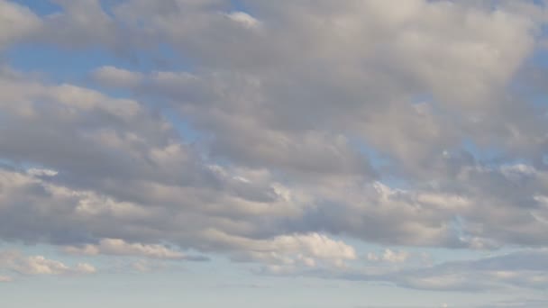 Rusko, časová prodleva. Vznik a rychlý pohyb bílé mraky různých tvarů na modré obloze na konci jara při západu slunce.