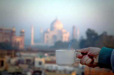 Taj Mahal'ı arka plan üzerinde elinde çay,
