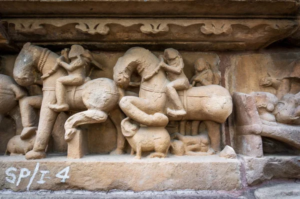 Processione del popolo indiano e cavalli su texture in pietra muro del tempio di Khajuraho, India . — Foto Stock