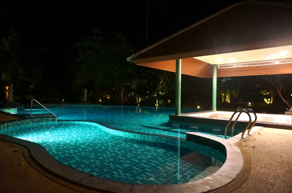 A pretty swimming pool in night at a local resort