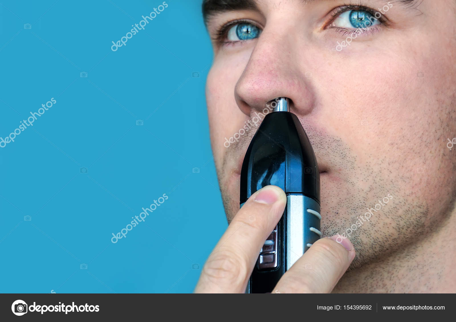 Handsome Young Man Remove Hair From His Nose With Trimmer Stock