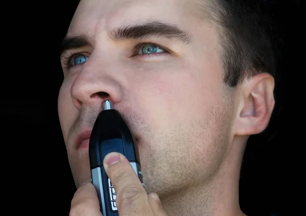 Чоловік використовує тример для волосся на носі — стокове фото