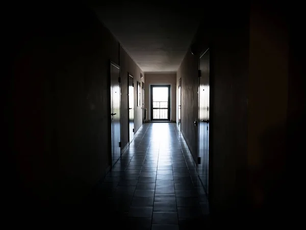 Largo pasillo oscuro con puertas a los apartamentos — Foto de Stock