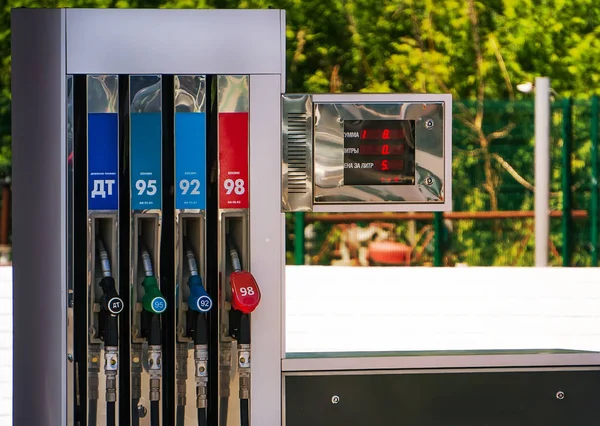 Pistolas de combustível de cores diferentes em um posto de gasolina . — Fotografia de Stock