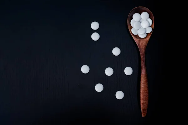 Bir tahta kaşık vitamini kapsülleri — Stok fotoğraf