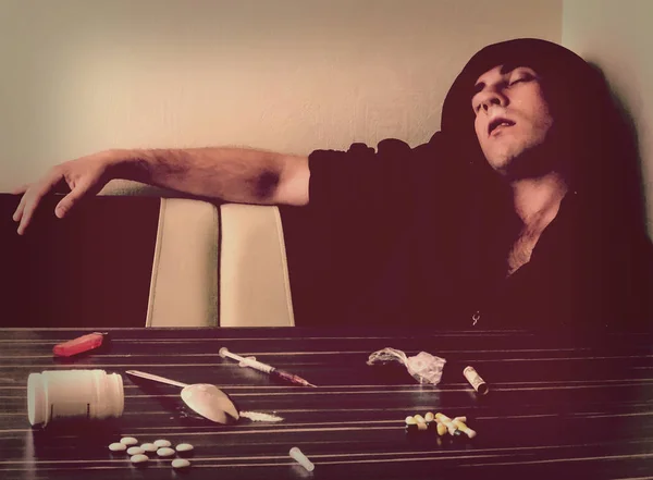 Young stoned man with drugs on the table — Stock Photo, Image