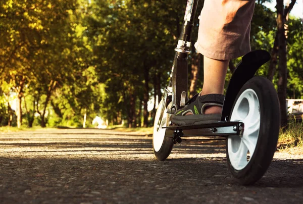 Füße in Sandalen auf dem Roller stehend — Stockfoto