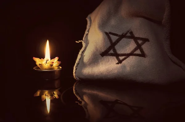 A burning candle next to the star of David — Stock Photo, Image