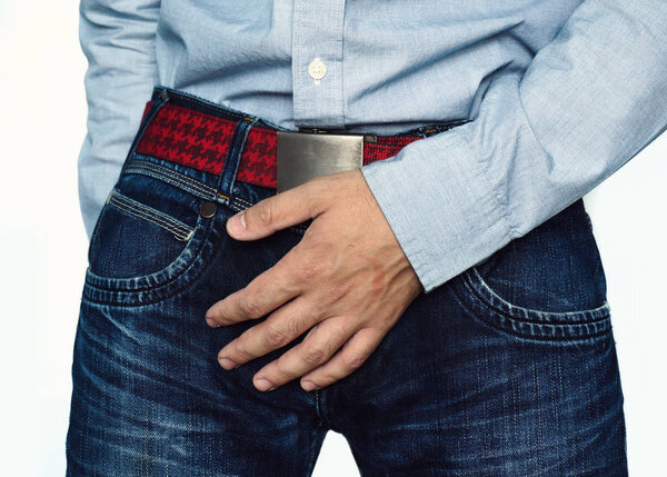 Close up of a man with hands holding his crotch