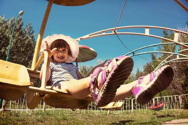 Lilla flickan barnet sitter på en roterande karusell — Stockfoto