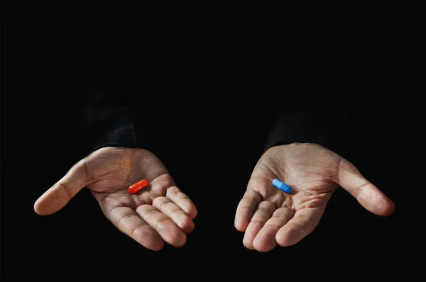 Rood en blauw pillen op hand geïsoleerd — Stockfoto