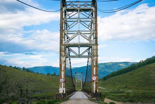 Ponte de suspensão através do rio da montanha — Fotografia de Stock