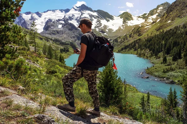 Caminante con mochila de pie en una ladera — Foto de Stock