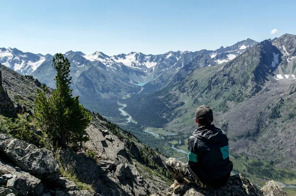 Hombre solitario mirando un valle del río sentado en una roca . — Foto de Stock