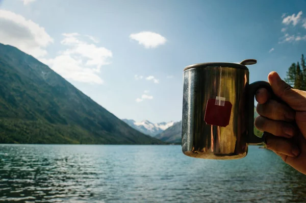 Nahaufnahme einer Thermoskanne mit Tee in der Hand eines Reisenden — Stockfoto