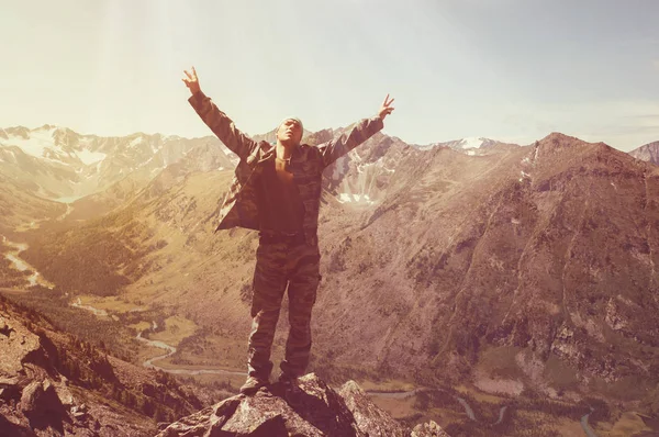 Caminante de pie en la cima de una montaña con las manos levantadas y disfrutando del amanecer — Foto de Stock