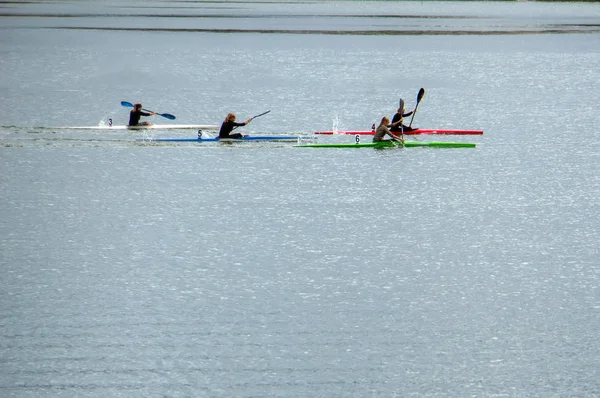 girls rowing on kayaks on the lake.