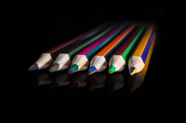 Siyah arkaplanda renkli kalemler