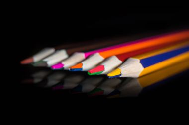 siyah ayna üzerinde renkli kalemler..