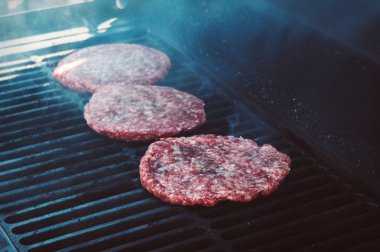 Hamburgers on Grill with Flames Cooked to Perfection clipart