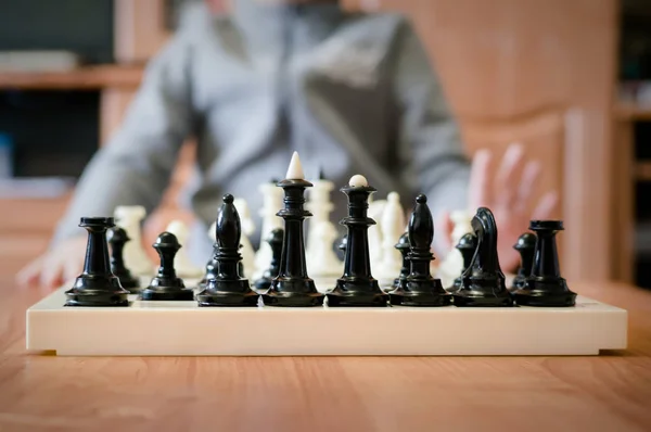 children playing chess at the table.