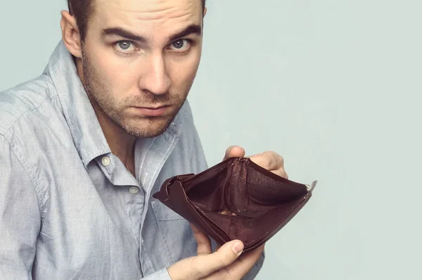 Empresario sosteniendo una cartera vacía en sus manos . — Foto de Stock