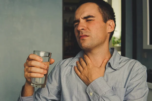 Une gorge desséchée et un verre d'eau à la main — Photo